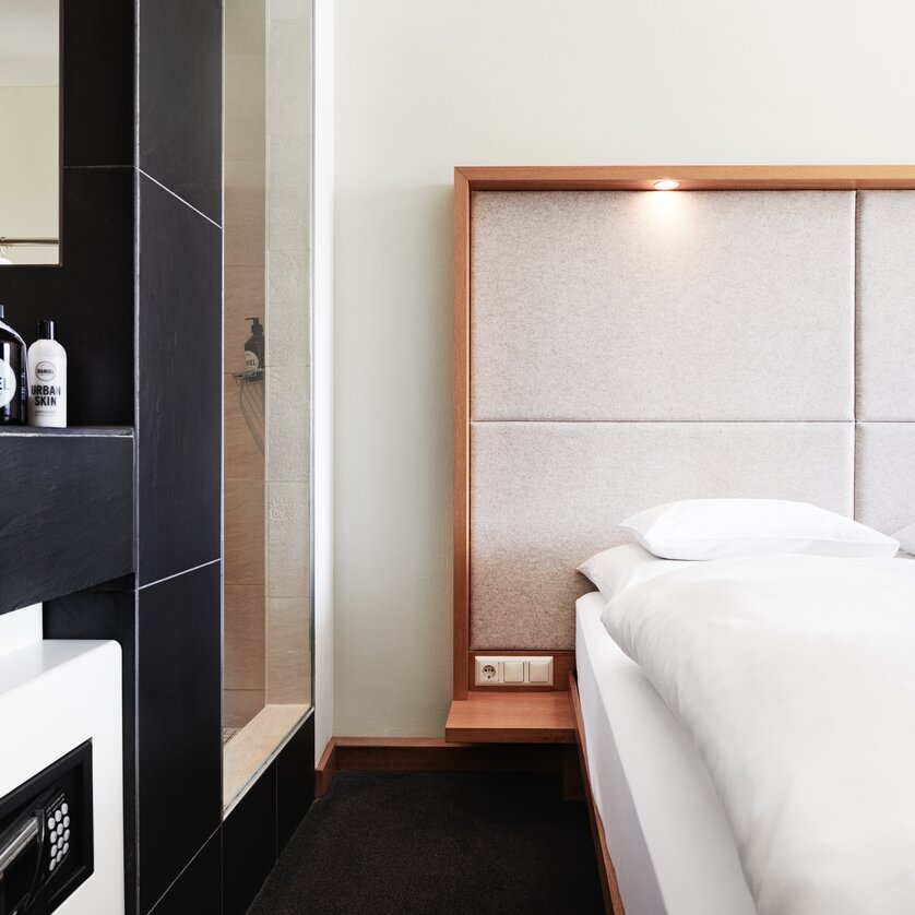 Bedroom | © Weitzer Hotels A view of a modern bedroom with a bathroom and beds. | © Weitzer Hotels