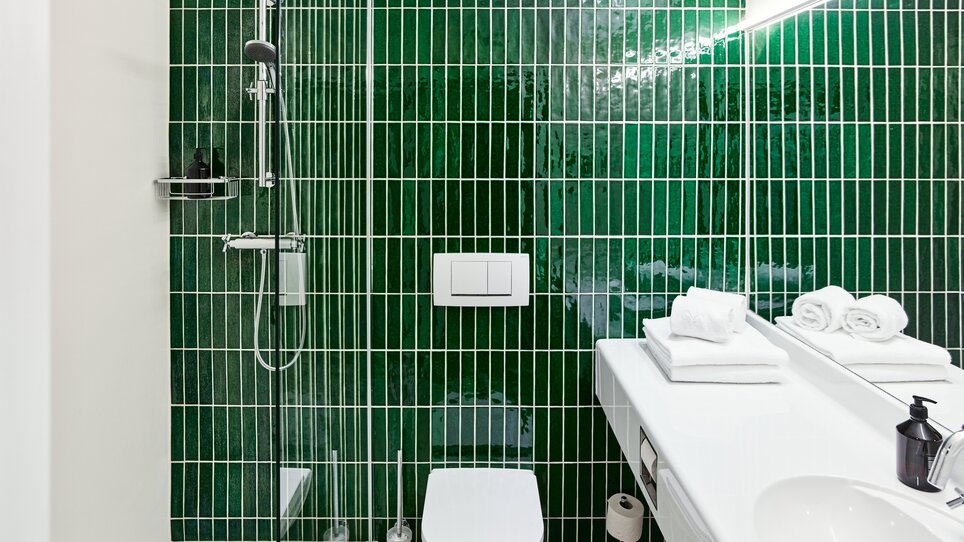 Stylish bathroom featuring a shower, toilet, and towels on the sink.