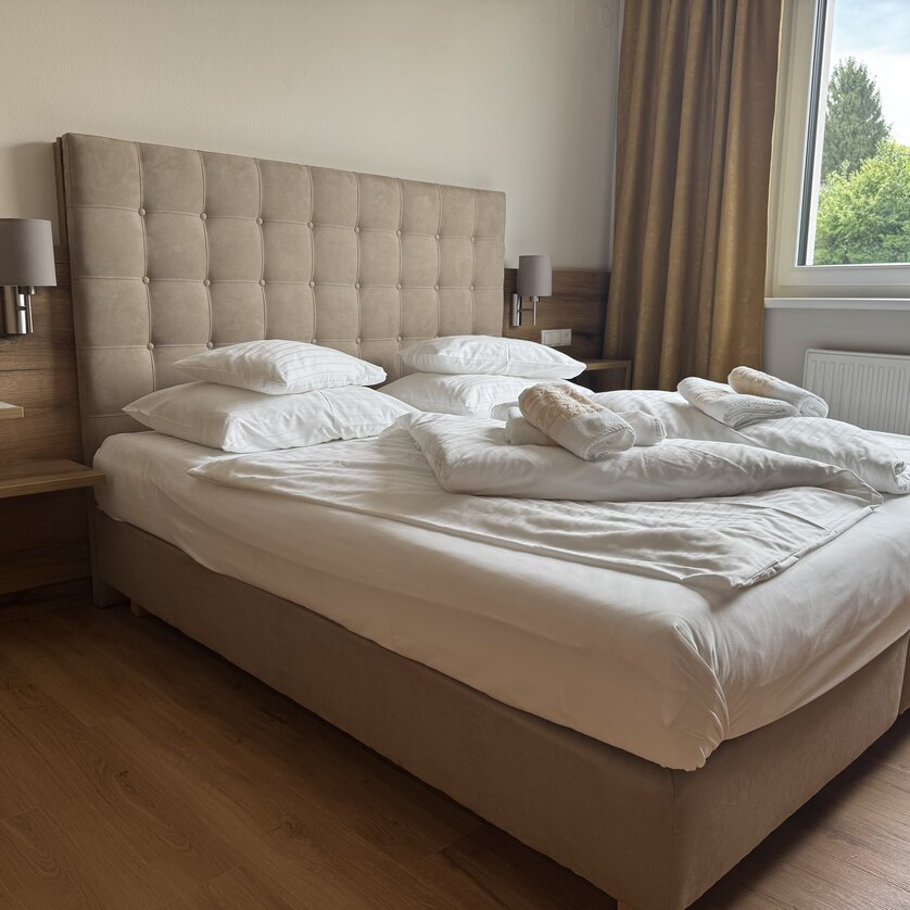 Bright room with a double bed, pillows, and a duvet. | © Der Marienhof