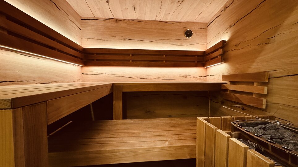 Interior view of a modern sauna featuring wooden decor and lighting accents. | © Der Marienhof