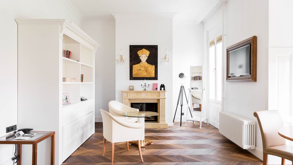 Ein helles Wohnzimmer mit Bücherregal, Kamin und Kunstwerk.