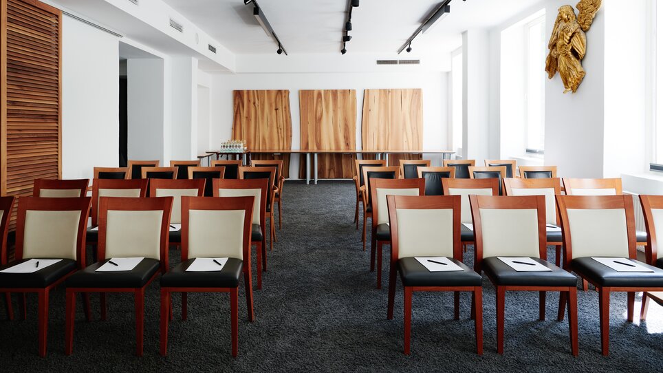 Ein Konferenzraum mit Stühlen und Holzpaneelen.