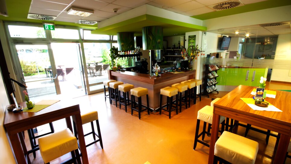 Ein Blick auf die Bar und Sitzplätze mit grüner Dekoration.