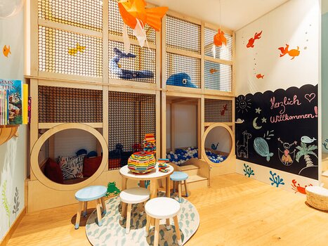 Colorful play area for kids with bookshelves and tables at the harry's home Graz-Smart City. | © harry's home Graz-Smart City - Daniel Zangerl