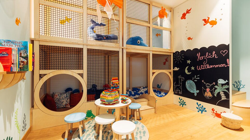 Bunter Spielbereich für Kinder mit Buchregal und Tischen im harry's home Graz-Smart City. | © harry's home Graz-Smart City - Daniel Zangerl