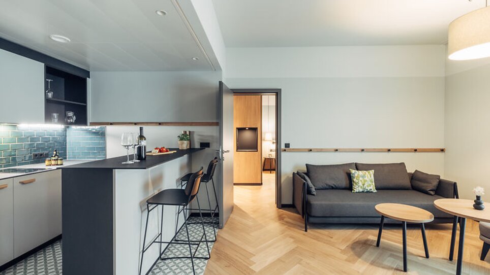 Offene Wohnküche mit Sofa und Esstisch in Graz im harry's home Graz-Smart City. | © harry's home Graz-Smart City- Daniel Zangerl