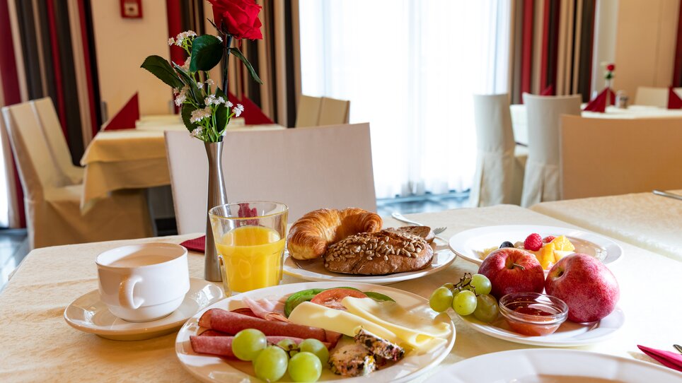 Ein Frühstückstisch mit Croissants, Obst, Käse, Wurst und Getränken. | © Harry Schiffer