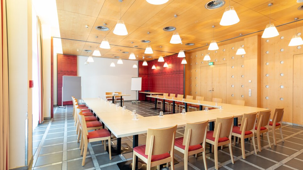 Moderner Besprechungsraum mit langen Tischen und Stühlen. | © Harry Schiffer