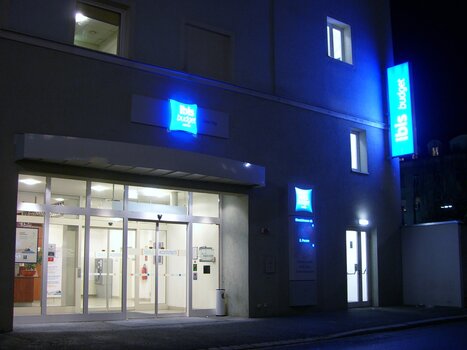 The IBIS Budget Graz City hotel with glowing signs at night. | © Ibis Budget