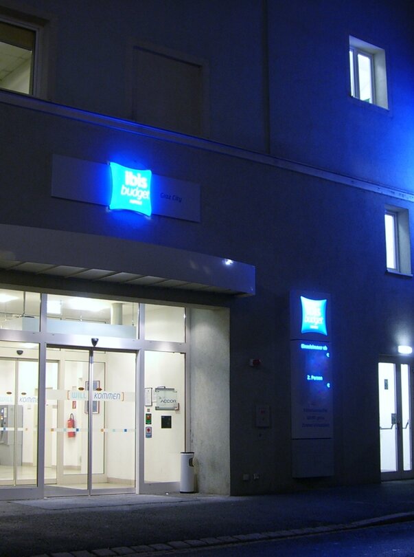 Das IBIS Budget Hotel Graz City mit leuchtenden Schildern bei Nacht. | © Ibis Budget