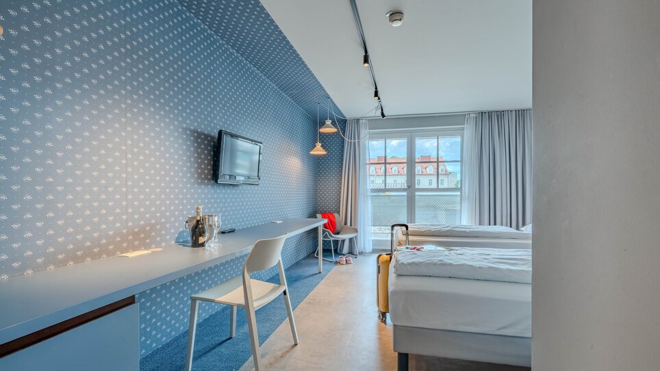 Zimmer im Hotel Ibis Styles Graz Messe, mit blauen Wänden und TV. | © Katharina Haag