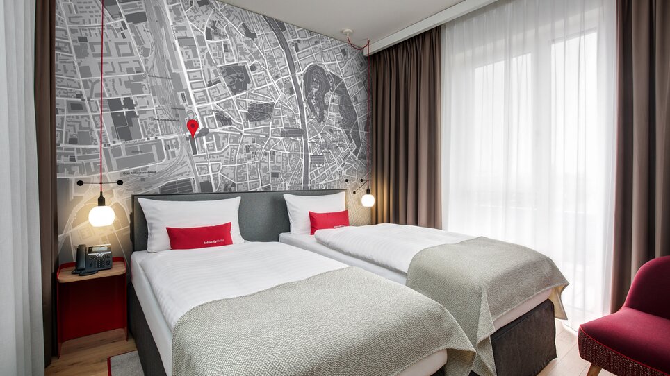 Gemütliches Hotelzimmer mit Stadtkarte von Graz an der Wand. | © ICHG