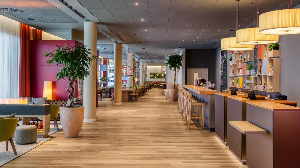 Helle Lobby mit Holzfußboden, Bar und Pflanzen in einem modernen Stil. | © ICHG