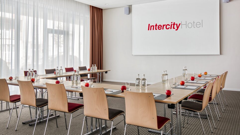 Konferenzraum im IntercityHotel mit Tischanordnung und Präsentationsfläche. | © ICHG