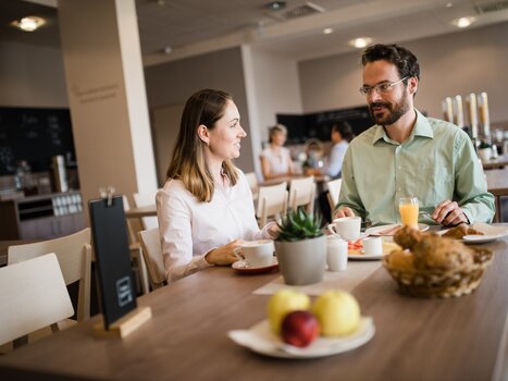 Zwei Personen beim Frühstück in einem hellen Restaurant. | © Jufa Hotels