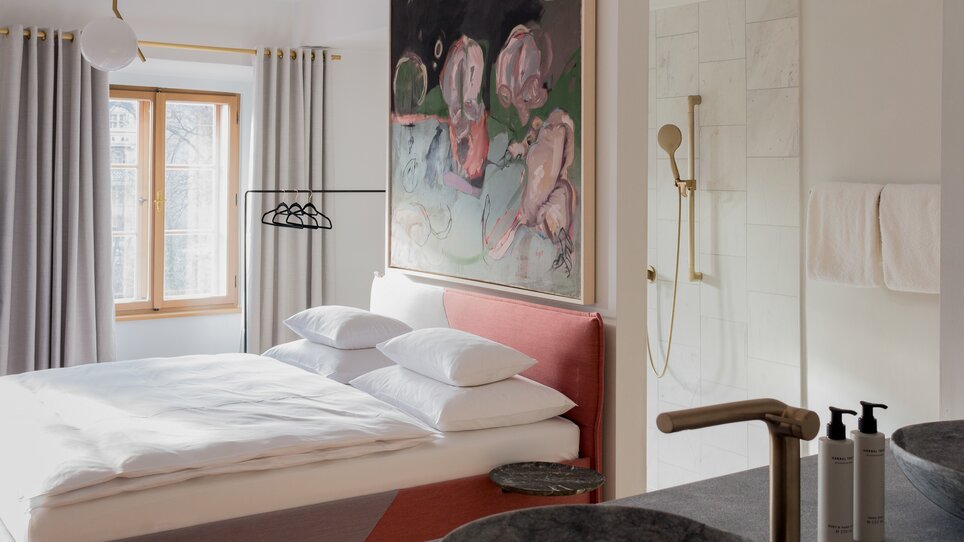 Modernes Schlafzimmer mit großem Bett und Kunstwerk. | © KAI 36