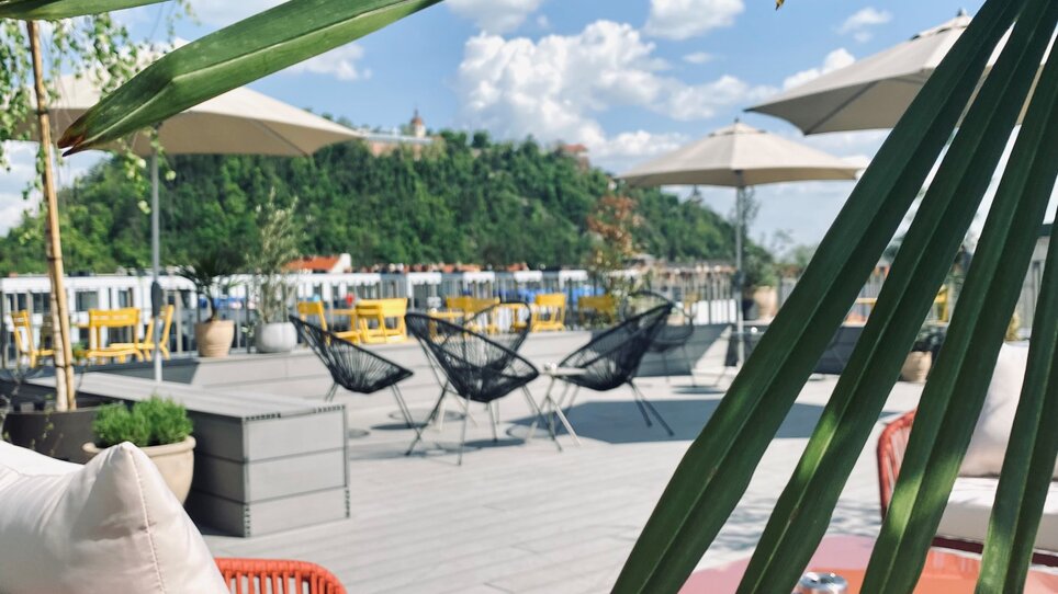 Gemütliche Terrasse mit stylischen Möbeln, Blick auf den Schlossberg und Umgebung in Graz. | © Lendhotel