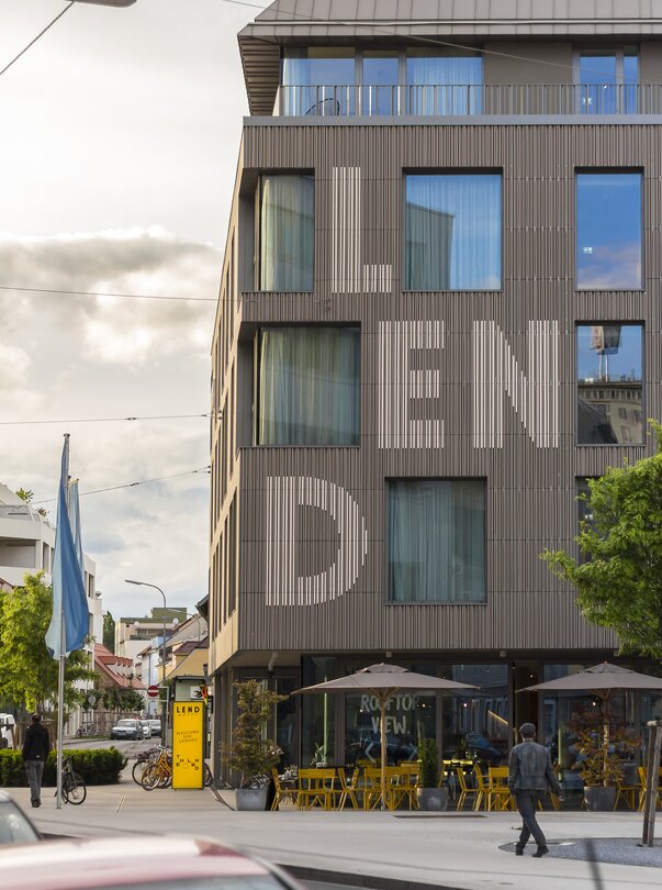 Fassade des Lendhotels in Graz mit großen Fensterflächen und Schriftzug "LEND" auf der Wand. | © Lendhotel