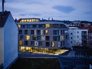 Lendhotel Graz mit beleuchteten Fenstern bei Dämmerung. | © Lendhotel