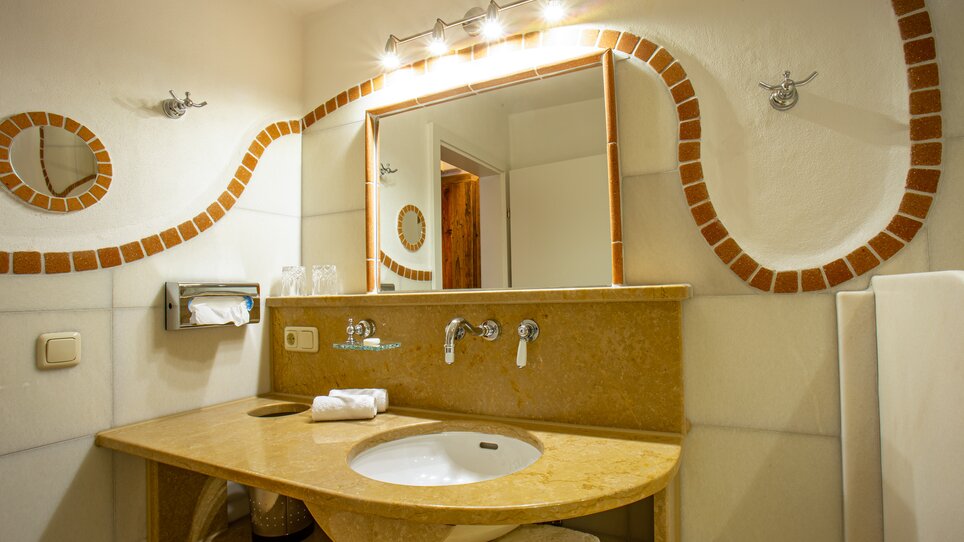 Badezimmer mit Waschbecken, Spiegel und Handtüchern. | © Lendplatzl GmbH