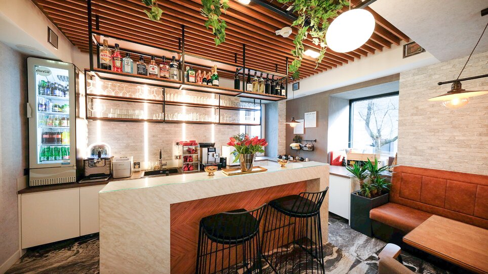 Moderner Barbereich mit Pflanzen und Getränken. | © NED Hotel