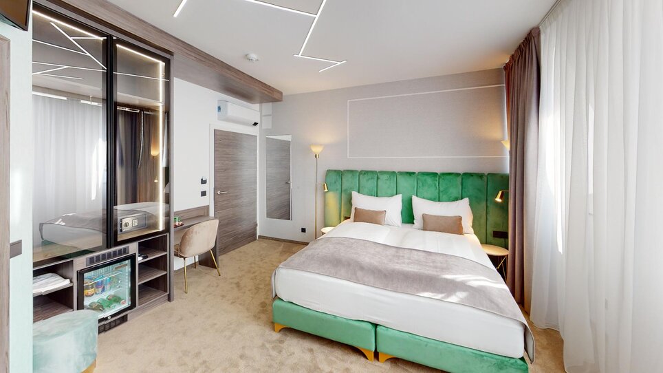 Modernes Doppelzimmer mit großem Bett und eleganter Einrichtung. | © NED Hotel