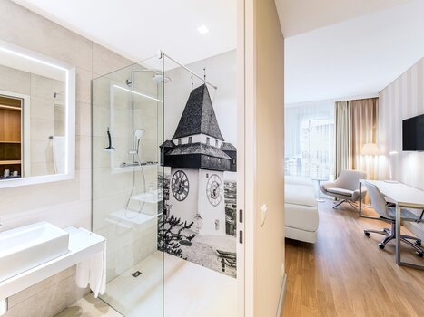 Camera doppia nell'Hotel NH Graz City con doccia e foto della torre dell'orologio di Graz. | © NH Hotel