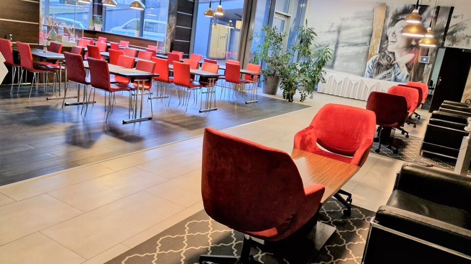 Innenansicht des Restaurants im Best Western Plus Plaza Hotel Graz mit roten Stühlen. | © PLAZA INN Graz City