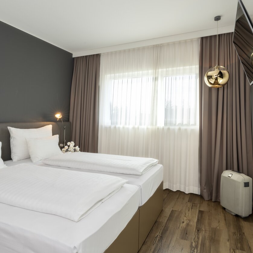 Modernes Zimmer mit Doppelbett und Fernseher. | © Plaza INN Graz