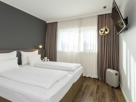 Modern room with double bed and TV. | © Plaza INN Graz