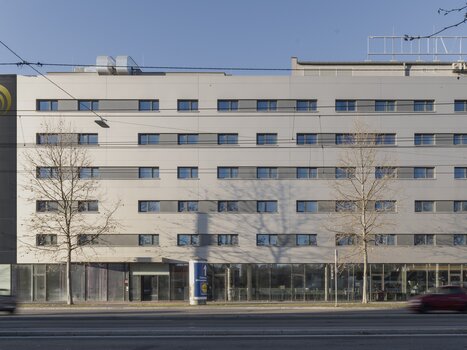 Hotel building with glass front and multiple windows. | © Plaza INN Graz
