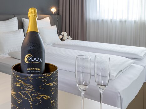 Double room with champagne and two glasses. | © Plaza INN Graz