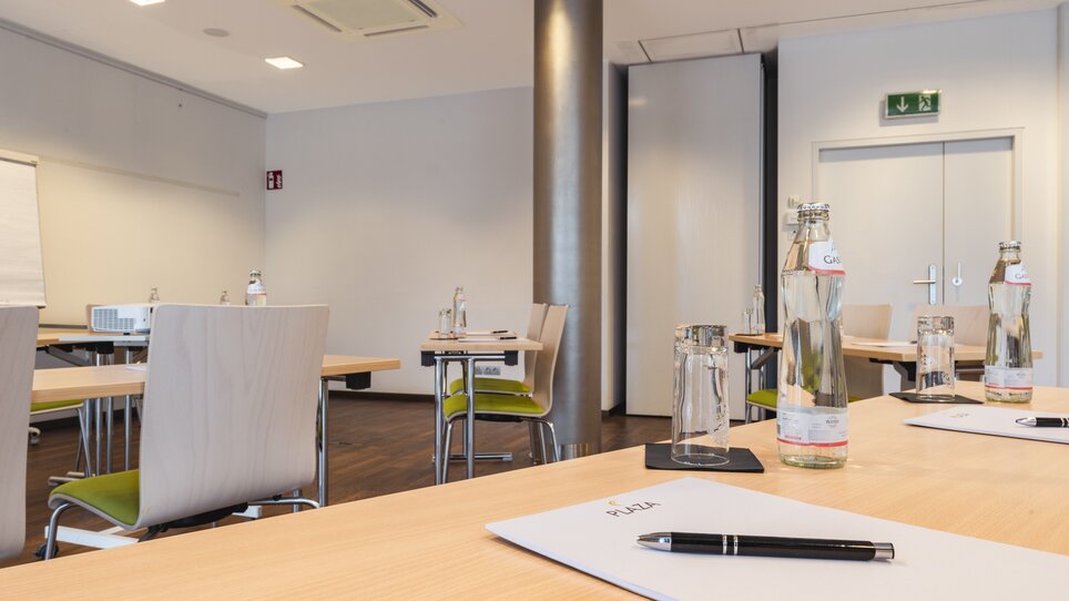 Tagungsraum im Hotel mit Tischen und Wasserflaschen. | © Plaza INN Graz