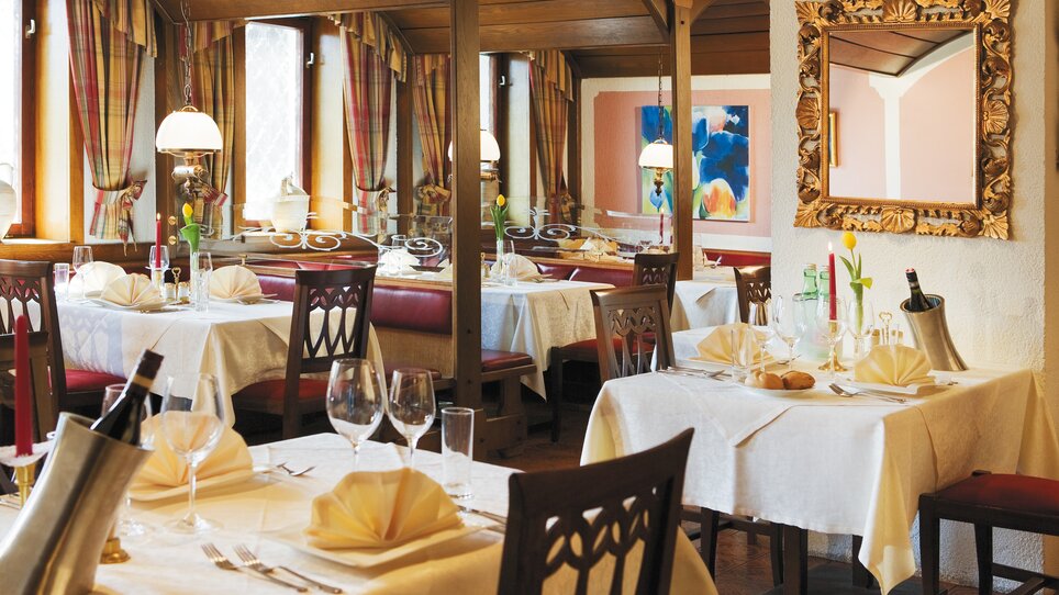 Rustikales Restaurant mit Tischdekoration und Doppelarmleuchtern. | © Roemerstube