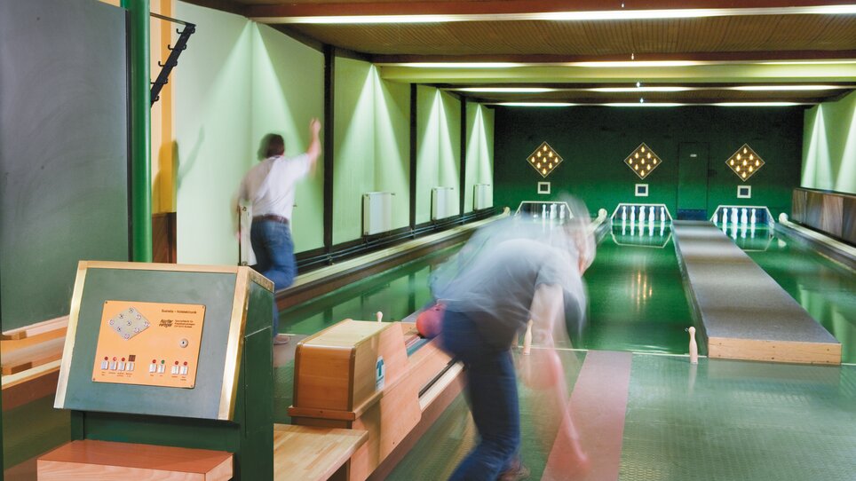 Zwei Personen beim Bowling in einer Halle. | © Roemerstube