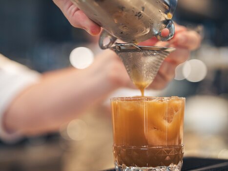 A barista pours coffee into a glass. | © Fabian Hasler