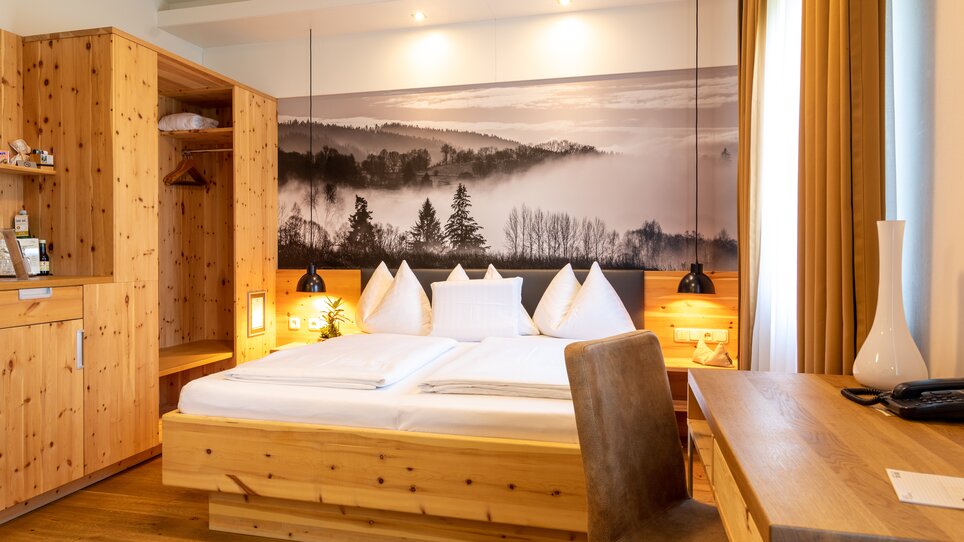 Gemütliches Doppelzimmer mit Holzregalen und Bett. | © Hotel Süd Art