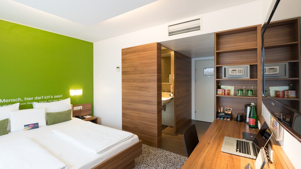 Helles Doppelzimmer mit großem Bett, Schreibtisch und Bad. | © Hotel Süd Art