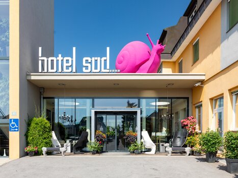 Eingang zum Hotel Süd Art mit großer pinker Schnecke. | © Hotel Süd Art 