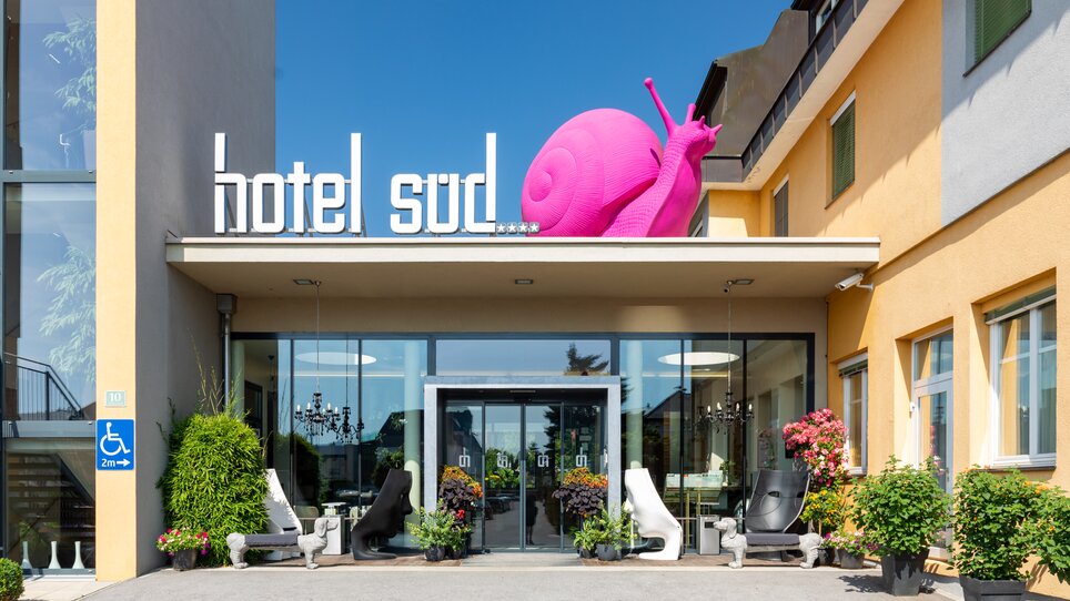 Eingang zum Hotel Süd Art mit großer pinker Schnecke. | © Hotel Süd Art 