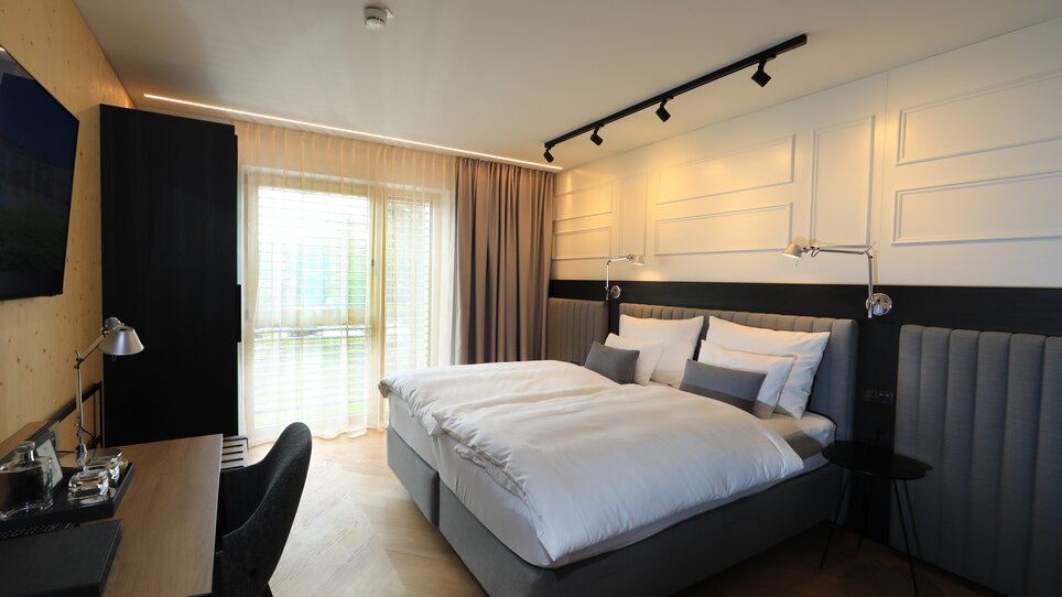 Una camera luminosa con letto matrimoniale e area di lavoro. | © Hotel Steiermarkhof