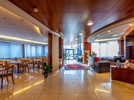 Modern hotel lobby with seating areas and reception desk. | © Hotel Stoiser Graz 