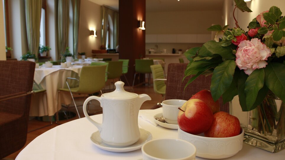 Stylish breakfast with a teapot, apples, and flowers. | © Rueckert