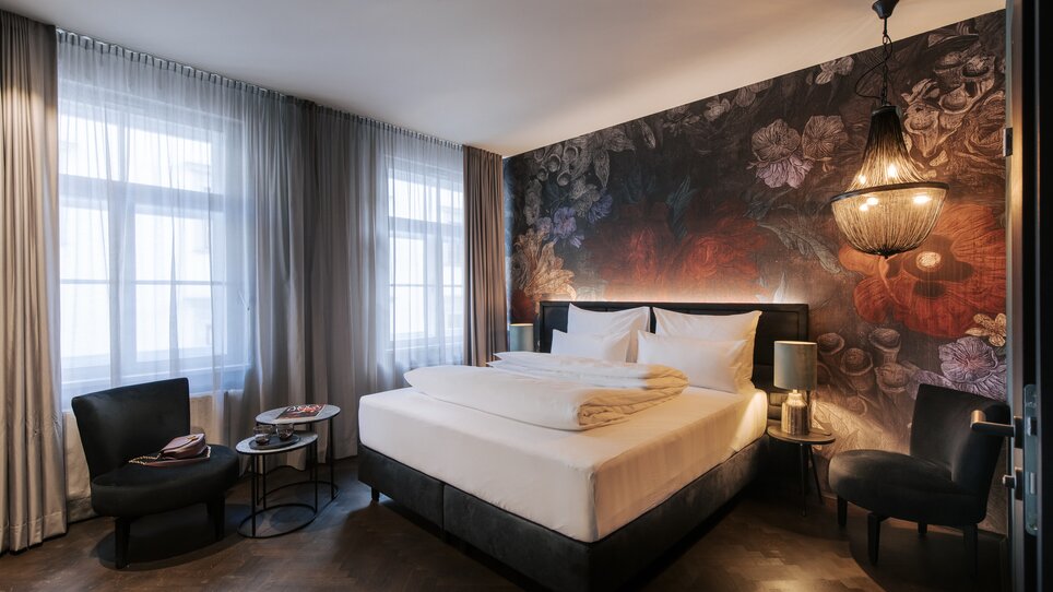 Camera elegante con un letto grande e design delle pareti stiloso all'Aiola Living. | © Aiola Living