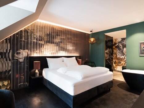 Camera elegante con design floreale e arredamento stiloso. | © Aiola Living