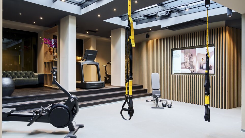 Palestra con bande TRX, tapis roulant e vogatore nell'Aiola Living. | © Aiola Living