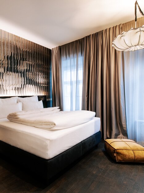 Stylish room with bed, ambient lighting, and artwork. | © Aiola Living